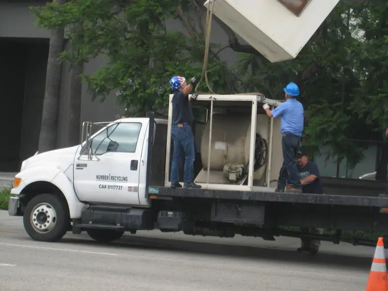 Two men in blue hats are on a truck.
